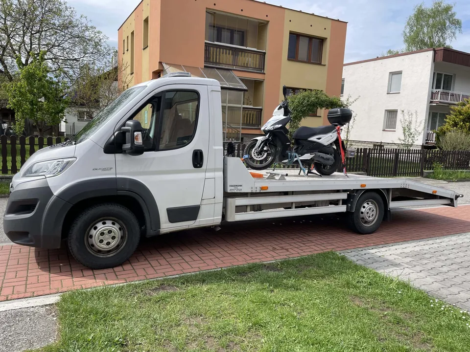 Odtahové vozidlo se skútrem naloženým na korbě